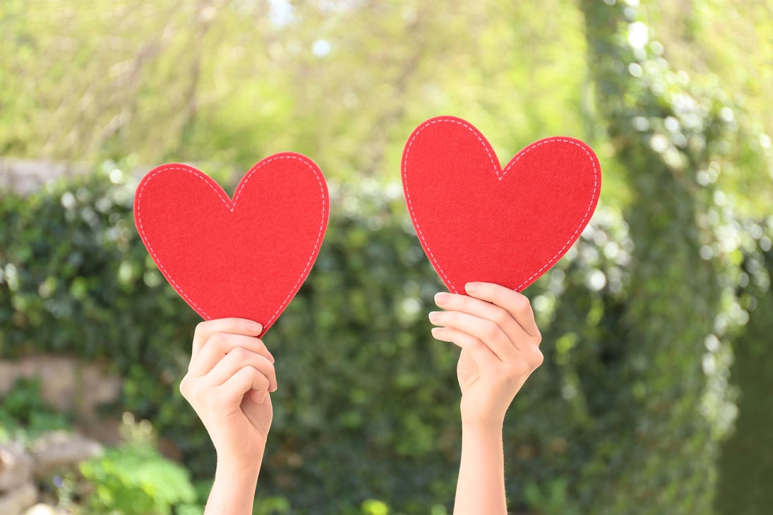 Woman Holding Red Hearts on Blurred Background